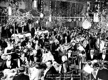 people sitting around their tables during a public academy awards ceremony
