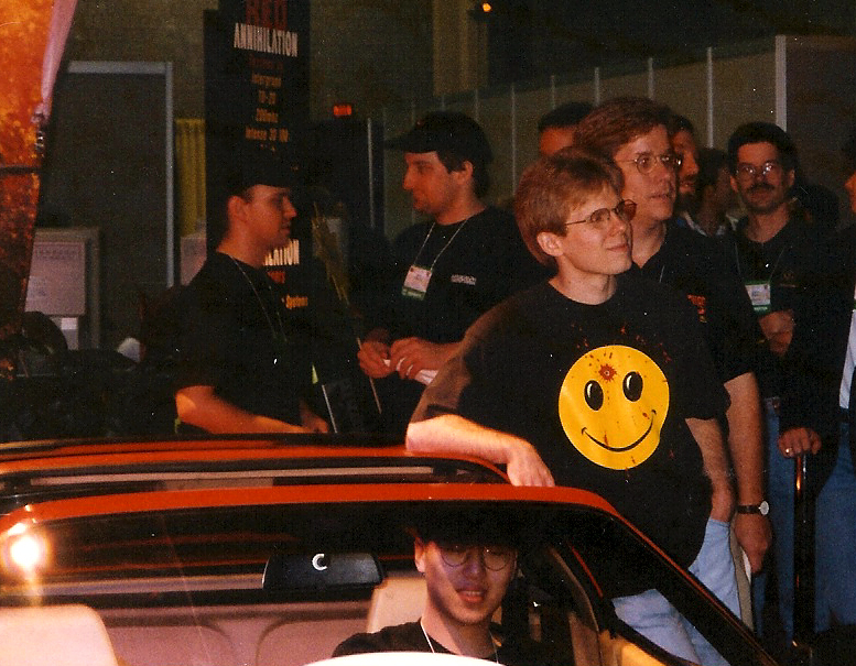 one person sitting in a red Ferrari car with another one standing next to it