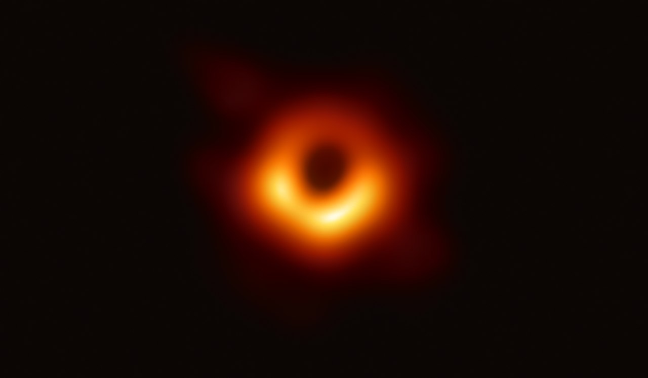 photograph of a black hole surrounded by orange light