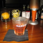 glass full of sazerac on a bar table